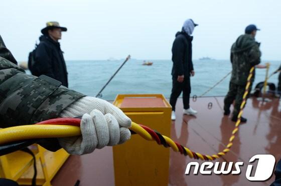 본문 이미지 - 세월호 침몰사고 29일째인 14일 오후 전남 진도군 관매도 인근 사고 해역에서 해군이 실종자 수색작업 중인 잠수사의 공기 호스를 붙잡고 있다. 2014.5.14/뉴스1 © News1 박지혜 기자