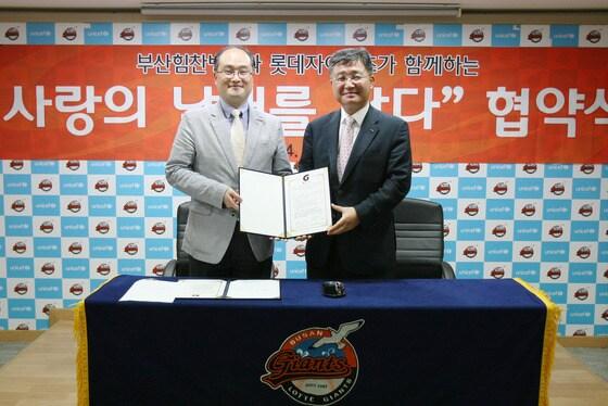 본문 이미지 - 롯데 최하진 대표이사(오른쪽)가  16일 부산 사직구장에서  힘찬병원 이춘기 원장과  사회공헌 협약식을 끝낸 뒤 협약서를 들고 포즈를 취하고 있다.   © News1  롯데 자이언츠 제공