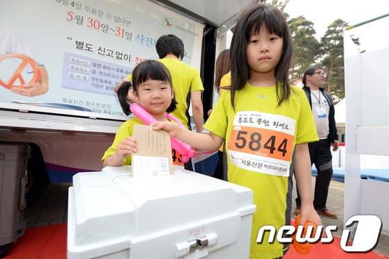 본문 이미지 - 지난 17일 오전 서울 마포구 상암동 상암월드컵공원 평화의광장에서 열린 제13회 서울신문 하프마라톤 대회 어린이 참가자들이 현장에 마련된 6·4지방선거 사전투표 체험관을 이용하고 있다. 2014.5.17/뉴스1 © News1   정회성 기자