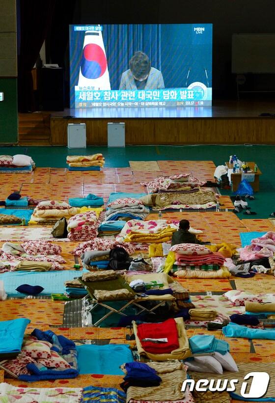 본문 이미지 - 세월호 침몰 사고 34일째인 19일 오전 전남 진도군 진도실내체육관에서 실종자 가족이 세월호 참사와 관련한 박근혜 대통령의 대국민담화 발표를 지켜보고 있다.이날 박근혜 대통령은 대국민담화를 통해 `세월호 침몰`과 관련해 국민들에게 사과하며 해경을 해체한다고 밝혔다. 2014.5.19/뉴스1 © News1 박지혜 기자