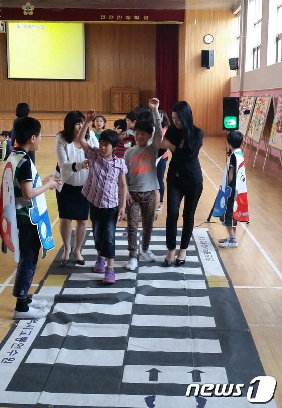 본문 이미지 - 19일 인천교통공사 직원들이 인천 인혜학교를 방문해 장애아동을 대상으로 교통안전 체험행사를 진행하고 있다. 사진 제공=인천교통공사.© News1  