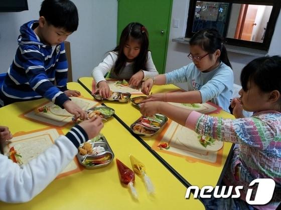 본문 이미지 - 임실군이 운영하는 지사랑작은도서에서 운영하는 '맛있는 책 요리하는 도서관'에서 어린이들이 책을 보며 요리를 하고 있다.(임실군 제공)2014.05.19/뉴스1© News1 