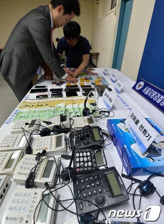 본문 이미지 - 서울지방경찰청 광역수사대 형사들이 서울 마포구 광역수사대 회의실에 진열된 인터넷 금융사기단 압수품들에 대해 설명하고 있다.(자료사진)/뉴스1 ⓒ News1