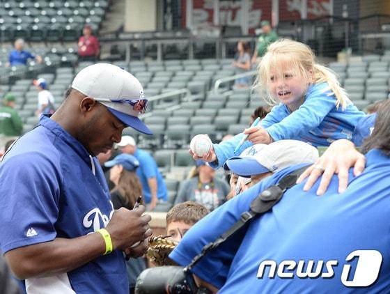 본문 이미지 - 금발의 어린이 팬이 22일 오전 8시 10분(이하 한국시간) 미국 뉴욕 플러싱의 시티 필드에서 열리는 메이저리그 LA 다저스와 뉴욕 메츠 경기에 앞서 푸이그에게 사인을 해 달라고 야구 공과 팬을 직접 건네고 있다. 다른 공에 사인을 하느라 눈길을 마주치지 못하고 있는 푸이그를 바라보는 소녀의 눈빛이 애절하다 푸이그는 이날 1-0으로 앞선 6회초 1사 후 좌중월 1점포를 날려 선발 류현진의 복귀전 도우미로 나섰다 . © News1 뉴욕=  권현진 특파원