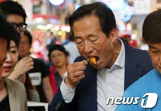 본문 이미지 - 6.4 지방선거 공식 선거운동 시작 후 첫 주말을 맞은 24일 정몽준 새누리당 서울시장 후보가 서울 도봉구 신창시장을 방문해 분식점에서 구입한 떡볶이를 입에 넣고 있다. 2014.5.24/뉴스1 © News1   오대일 기자