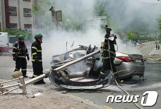 본문 이미지 - 25일 낮 12시 22분께 강원 정선군 정선읍 북실리 현대아파트 앞 회전교차로 인근 가로수를 들이 받은 소나타 승용차&#40;운전자 전모씨·52&#41;에 불이 나 소방대원들이 진화 및 구조작업을 벌이고 있다. 이 사고로 2명의 사상자가 발생했다.&#40;정선소방서 제공&#41; 2014.5.25/뉴스1 © News1   이예지 기자