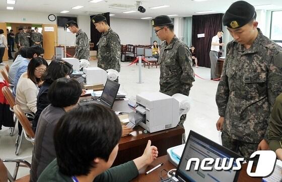 본문 이미지 - 6.4 지방선거 사전투표가 시작된 30일 오전 제주특별자치도의회 의원회관에 마련된 투표소에 장병들이 투표용지를 받기 위해 줄을 서서 기다리고 있다. 2014.5.30/뉴스1 © News1 이상민 기자