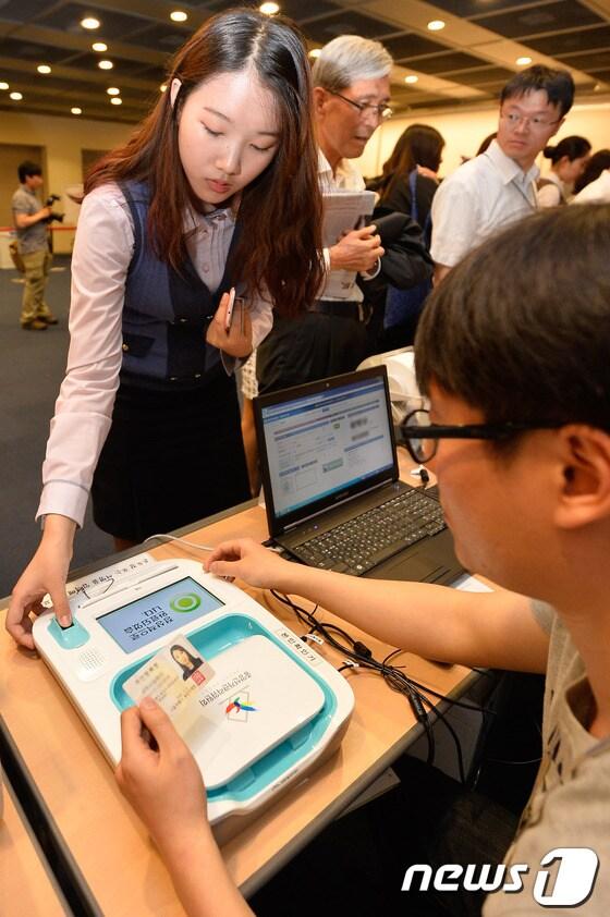 본문 이미지 - 6·4 지방선거 사전투표 첫날인 30일 오전 서울 종로구 대한상공회의소에서 한 유권자가 지문 확인을 하고 있다. 2014.5.30/뉴스1 © News1   송은석 기자