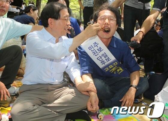 본문 이미지 - 6·4 지방선거 선거운동 기간이던 지난달 31일 서울 양천구 신정동 양천공원에서 열린 가족 피크닉 행사에 참석한 박원순 서울시장&#40;왼쪽&#41;이 조희연 서울시교육감 당선자 입에 김밥을 넣어주고 있다./뉴스1 © News1 