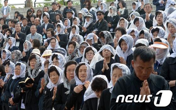 본문 이미지 - 경기 안산 화랑유원지에서 열린 세월호 침몰사고 희생자 추모 미사에서 천주교 신도들이 기도를 하고 있다. © News1   민경석 기자