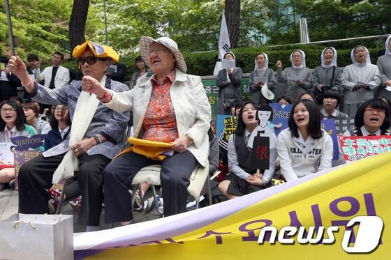 본문 이미지 - 7일 서울 종로구 중학동 주한일본대사관 앞에서 열린 1125차 '일본군 위안부 문제해결을 위한 정기 수요시위'에서 김복동, 길원옥 할머니와 참가자들이 일본정부의 공식 사죄를 촉구하는 구호를 외치고 있다. 2014.5.7/뉴스1 © News1   한재호 기자