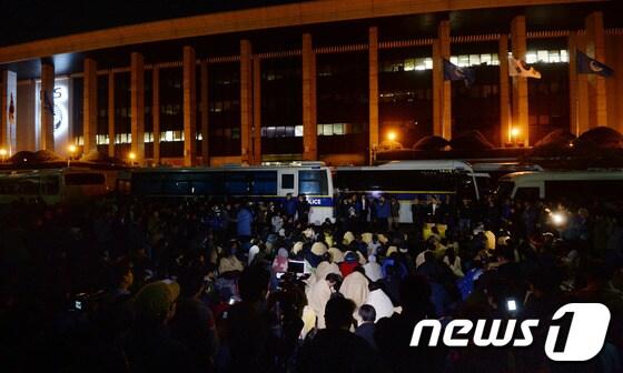 본문 이미지 - 영정을 든 세월호 참사 유족들이 8일 밤 KBS 본관 앞에서 김시곤 KBS 보도국장과의 면담을 요구하며 KBS로 진입을 시도하고 있다. 유가족들의 KBS 항의방문은 김시곤 KBS 보도국장의 세월호 관련 발언 보도에서 2014.5.8/뉴스1 © News1 손형주 기자