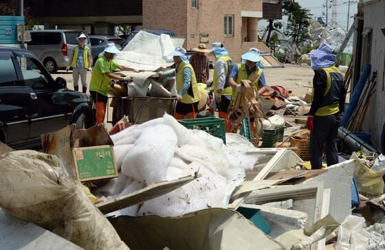 본문 이미지 - '토네이도' 피해를 입은 경기 고양시 일산서구 구산동 일원에서 11일 오후 봉사활동에 나선 농협하나로클럽 관계자들이 바람에 날아온 온실시설물을 수거하고 있다. 기상청은 10일 오후 7시께 고양시 장월나들목 인근 한강 둔치에서 토네이도 현상이 발생해 한시간 동안 지속됐다고 밝혔다. 이번 토네이도로 구산동 일원 장미 재배용 비닐하우스 등 원예시설물 20동 이상이 파손되는 피해를 입었다. 2014.6.11/뉴스1 © News1   