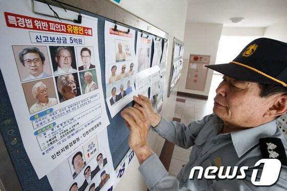 본문 이미지 - 전국 24만곳에서 유병언 전 세모그룹 회장 검거를 위한 임시반상회가 열리는 13일 서울시내 한 아파트단지에서 관리원이 유 전 회장과 아들 대균씨의 수배 전단지를 알림판에 붙이고 있다. © News1 유승관 기자