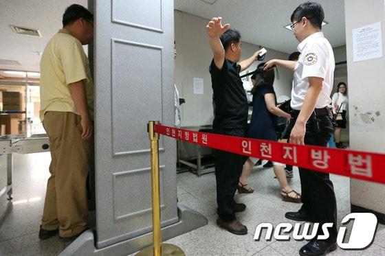 본문 이미지 - 유병언 전 세모그룹 회장의 최측근 8명에 대한 첫 재판이 열린 16일 오전 인천지방법원 법정으로 향하는 출입구에서 법원 관계자들이 방청객에 대한 검색을 벌이고 있다.인천지법 형사12부(부장판사 이재욱)는 이날 특정경제범죄 가중처벌법상 횡령·배임 등 혐의로 구속기소된 송국빈 다판다 대표, 박승일 아이원아이홀딩스 감사, 이재영 ㈜아해 대표, 이강세 ㈜아해 전 대표, 변기춘 천해지 대표, 고창환 세모 대표, 김동환 아이원아이홀딩스 이사, 오경석 헤마토센트릭라이프연구소 대표 등도 8명에 대한 첫 공판을 열었다. 2014.6.16/뉴스1 © News1   한재호 기자