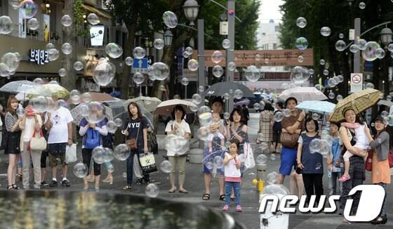 본문 이미지 - 지난 20일 오후 서울 종로구 북인사마당에서 우산을 쓴 시민들이 비눗방울 공연을 보고 있다. /뉴스1 © News1   안은나 기자