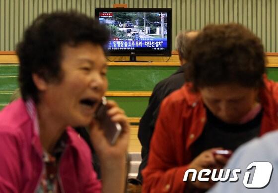 본문 이미지 - 동부전선 최전방 GOP에서 총기를 난사하고 무장 탈영한 임모(22) 병장이 강원도 고성군 명파리 민통선 이북 지역에서 우리 군과 교전 후 대치 중인 가운데 22일 오후 교전지역 인근 마을 주민들이 야간 돌발 상황에 대비해 인근 초등학교 체육관으로 대피해 안부를 묻는 전화를 하고 있다. 2014.6.22/뉴스1 © News1   한재호 기자