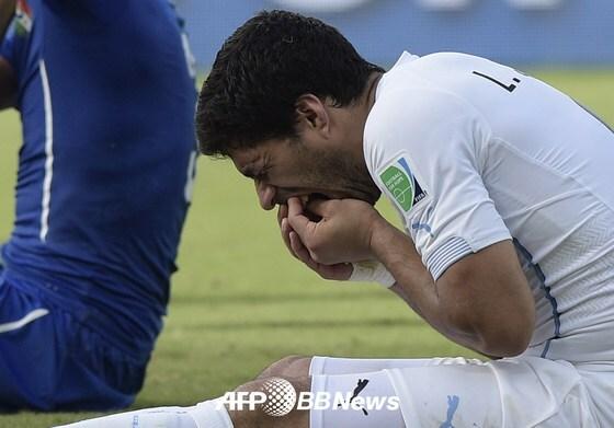 본문 이미지 - 우루과이 축구대표팀의 루이스 수아레스가 25일&#40;한국시간&#41; 브라질 나타우의 두나스 경기장에서 열린 2014 브라질 월드컵 D조 조별예선 3차전 이탈리아와의 경기에서 고통스러운 표정으로 이를 만지고 있다. © AFPBBNews=News1 