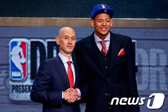 본문 이미지 - 마판 증후군으로 선수생활을 마감하게 된 아이재아 오스틴(오른쪽)이 27일(이하 한국시간) 뉴욕 바클레이즈 센터에서 열린 NBA 2014 드래프트에서 NBA 사무국에 의해 지명된 뒤 애덤 실버 총재와 악수하고 있다.© AFP=News1  