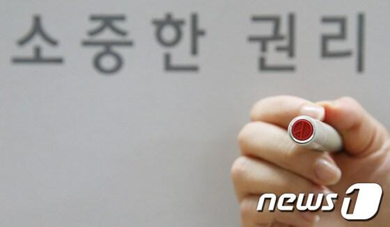 본문 이미지 - 제6회 전국동시지방선거를 하루 앞둔 3일 서울 동대문구 문화회관에 마련된 답십리 제2동 제3투표소에서 한 직원이 투표도장을 보여 주고 있다. 2014.6.3/뉴스1 © News1   송원영 기자