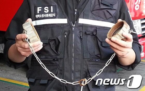 본문 이미지 - 소화전의 방수구 뚜껑을 훔쳐 고물상에 팔아 넘긴 70대 노인이 태백소방서 소속 한 소방관의 잠복 끝에 붙잡혀 경찰로 인계돼 조사를 받고 있는 가운데 한 소방관이 방수구 뚜껑을 보여주고 있다.(태백소방서 제공) © News1   이예지 기자