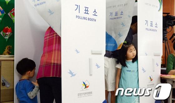 본문 이미지 - 6회 전국동시지방 투표일인 4일 오전 서울 종로구 재동초등학교에 마련된 가회 제1투표소에서 부모를 따라 온 어린이들이 호기심 가득한 눈으로 기표소를 지켜보고 있다. 2014.6.4/뉴스1 © News1 허경 기자