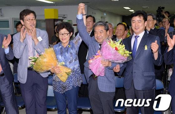본문 이미지 - 4일 오후 제6회 전국동시지방선거에서 당선이 유력한 진보 단일 후보인 이재정 경기도교육감 후보가 부인 박영희 여사와 손을 들어 기뻐하고 있다.2014.6.4/뉴스1 © News1   이동원 기자