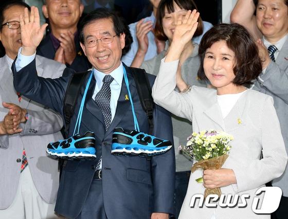 본문 이미지 - 박원순 새정치민주연합 서울시장 후보와 부인 강난희 여사가 5일 새벽 서울 종로 선거 캠프에서 자원봉사자들에게 배낭과 운동화, 꽃다발을 받고 환하게 웃으며 손을 흔들고 있다. 2014.6.5/뉴스1 © News1   박정호 기자