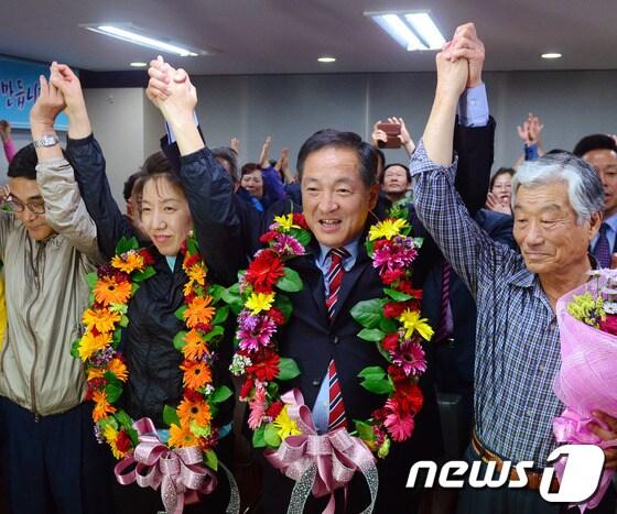 본문 이미지 - 5일 이병선 속초시장 후보가 당선이 확실해지자 조양동에 위치한 선거캠프에서 꽃 목걸이를 걸고 환호를 하고 있다. 2014.6.5/뉴스1 © News1   엄용주 