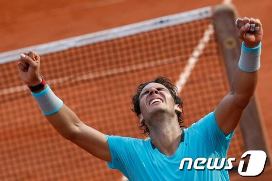 본문 이미지 - 세계랭킹 1위 라파엘 나달&#40;스페인&#41;이 9일&#40;한국시간&#41; 벌어진 프랑스 오픈 테니스 대회 남자 단식 결승전에서 노박 조코비치&#40;세르비아&#41;를 3-1로 꺾고 우승을 확정한 뒤 두 팔을 치켜들며 기뻐하고 있다. © AFP=News1  