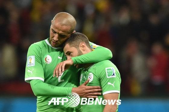 본문 이미지 - 알제리 대표팀의 마지드 부게라(왼쪽)와 메드히 라센이 1일(한국시간) 벌어진 2014 브라질 월드컵 16강 독일과의 경기에서 연장 접전 끝에 1-2로 패한 뒤 서로 부둥켜 안으며 격려하고 있다. © AFP BBNews=News1