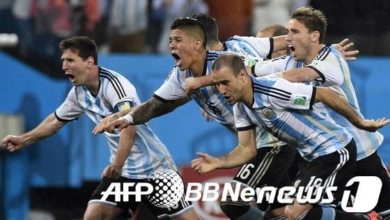 본문 이미지 - 리오넬 메시(왼쪽)를 비롯한 아르헨티나 축구대표팀 선수들이 2014 브라질 월드컵 4강전 네덜란드와의 경기에서 승부차기 끝에 승리를 거두자 환호하고 있다. © AFPBBNews=News1   