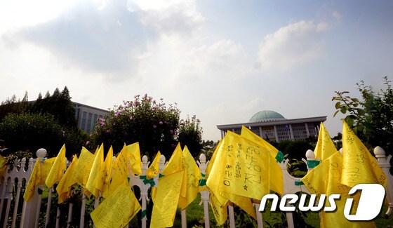 본문 이미지 - 16일 오후 서울 여의도 국회 담벼락에 1박2일 도보행진에 나선 세월호 침몰 사고 생존학생들이 꽂아둔 노란 깃발이 걸려 있다.세월호 침몰사고 생존학생들과 학부모 등은 어제 오후 5시 수업을 마친 후 학교에서 거리로 나와 국회를 향해 1박2일 일정의 도보행진을 했다. 2014.7.16/뉴스1 © News1   양동욱 기자