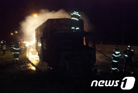 본문 이미지 - 23일 오후 8시 42분께 강원 강릉시 왕산면 영동고속도로 대관령 2터널 인근 인천방면 218㎞ 지점에서 우편물 수송 5t 화물차(운전자 김모씨·61)에서 불이나 소방대원들이 진화 중이다. 이 불은 차량과 일부 우편물을 태우는 등 9200여만원(소방서 추산)의 재산피해를 내고 50여분 만에 꺼졌다.(강릉 소방서 제공) 2014.7.23/뉴스1