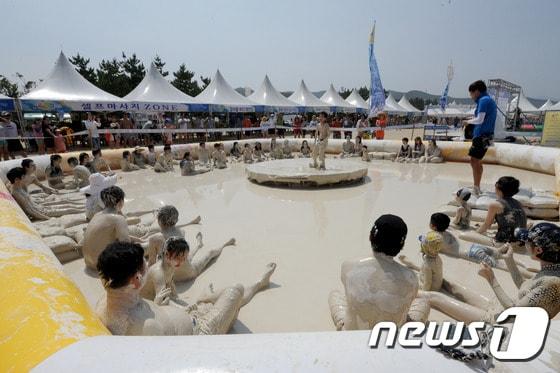 본문 이미지 - 27일 강원 동해시 망상해변에서 피서객들이 지역 천연광물인 화이트견운모를 이용한 축제를 즐기고 있다. 이곳에서는 내달 3일까지 망상해변축제가 진행되며 현재까지 50여 만명의 피서객이 방문했다. 2014.7.27/뉴스1