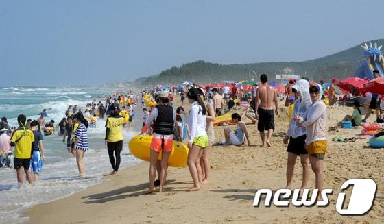 본문 이미지 - 본격적인 피서철이 시작된 27일 강원 동해시 망상해변이 전국의 피서객으로 가득하다. 이날 동해안 지역은 파도가 높아 경포해변은 해수욕이 금지됐으나 망상해변은 안전요원의 인도 아래 해수욕이 이뤄졌다. 이곳에서는 내달 3일까지 망상해변축제가 진행되며 현재까지 50여 만명의 피서객이 방문했다. 2014.7.27/뉴스1