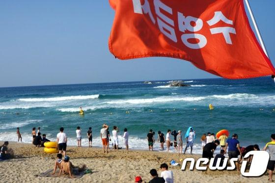 본문 이미지 - 27일 강원 강릉시 경포해변을 찾은 피서객들이 너울성 파도로 입수가 금지되어 바다에 들어가지 못하고 있다. 이날 강원 동해안 대부분의 해수욕장은 너울성 파도로 입수가 금지됐다. 이날 오전11시 기상청에서는 오후 해상 예보로 풍속 8~12m/s, 파고 1~2m가 일 것으로 발표했다. 2014.7.27/뉴스1
