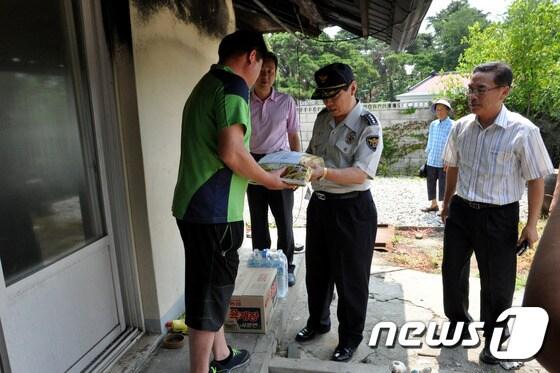 본문 이미지 - 강릉경찰서는 30일 최근 연쇄방화로 피해를 입은 주민의 집을 방문해 쌀과 라면 등의 구호물품을 전달하며 위로하는 시간을 가졌다. (사진제공=강릉경찰서) 2014.7.30/뉴스1