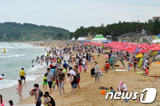 본문 이미지 - 지난 1일 개장한 이후 첫 주말을 맞은 5일 속초해수욕장에는 많은 사람들로 북적이고 있다. 속초해수욕장은 강원도 동해안 92개 해수욕장 가운데 가장 빨리 문을 열었다. 2014.7.5/뉴스1 © News1   엄용주 