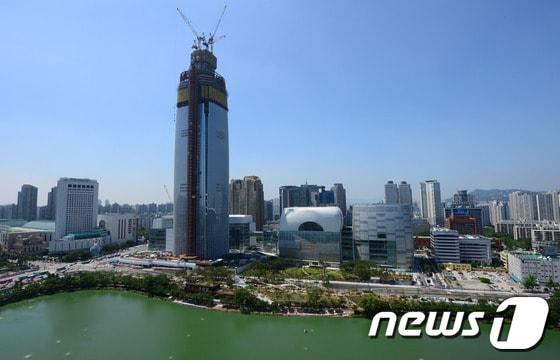 본문 이미지 - 7일 오후 서울 송파구 잠실동 석촌호수 옆 제2롯데월드 신축공사가 한창이다. 석촌호수 수위 저하와 이로인한 싱크홀 우려 등이 지속적으로 제기되는 가운데 이날 "석촌호수 수위 저하에 대한 전문가 자문회의 결가 보고서"가 공개됐다. 보고서는 지난해 12월 서울시와 송파구, 전문가 등으로 구성된 자문회의 결과를 토대로 작성된 것으로 제2롯데월드 건설과 석촌호수 수위, 인근 지하철 9호선 공사 등을 종합적으로 분석했다. 자문위는 2011년부터 석촌호수의 물 유입량과 수위변화를 지속적으로 모니터링 한 결과 호수의 자연증발산량 등을 고려하더라도 이 해 7월부터 수위가 저하되는 양상이 심화됐다고 밝혔다. 2014.7.7/뉴스1 ⓒ News1