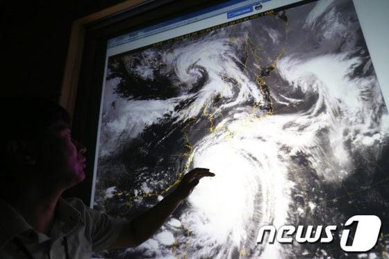 본문 이미지 - 제8호 태풍 너구리가 한반도 남동쪽 일본 열도 방면으로 북상하고 있는 8일 오후 서울 동작구 기상청에서 예보관이 천리안 위성이 보내온 기상도를 통해 태풍 경로를 설명하고 있다. 2014.7.8/뉴스1 © News1 한재호 기자