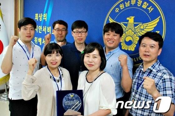 본문 이미지 - 인터넷 물품사기 피해자 49명으로부터 전달받은 감사패를 들고 파이팅을 외치고 있는 수원남부경찰서 사이버수사팀 직원들. © News1  