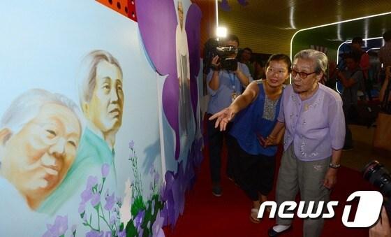 본문 이미지 - 12일 서울시청 시민청에서 개막한 일본군 위안부 피해자 할머니들을 위한 전시회 "아픔으로 날다"에서 김복동 할머니가 전시작품을 관람하고 있다. 2014.8.12/뉴스1 ⓒ News1 양동욱 기자