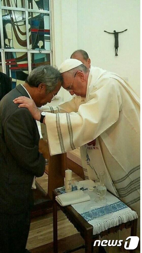 본문 이미지 - 세월호 희생자 유가족인 이호진씨가 17일 프란치스코 교황에게 세례를 받고 있다. (교황방한위원회 제공) ⓒ News1