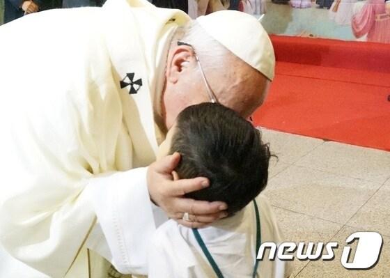 본문 이미지 - 서울 명동대성당 미사 후 그림을 선물한 4살 어린아이를 축복하고 있는 프란치스코 교황./ⓒ News1