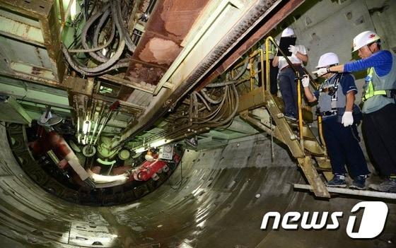 본문 이미지 - 국토교통부와 한국시설안전공단 등으로 구성된 특별점검반이 20일 오후 서울 송파구 방이동 지하철 9호선 920공구 공사현장 내부에서 터널 굴착장비인 실드TBM을 점검하고 있다. 국토부는 최근 송파구 일대에서 발생한 싱크홀 및 동공이 지하철 9호선 건설을 위해 석촌지하차도 하부를 통과하는 터널공사가 원인으로 추정됨에 따라, 이날부터 전국에서 시행되는 지하철공사와 도심지의 대형 건축공사 현장을 대상으로 주변 지역이 지반·지하수 변위, 굴착 안전성 등 시공상태, 공사장 주변의 안전관리 등을 점검한다. 2014.8.20/뉴스1 ⓒ News1 양동욱 기자