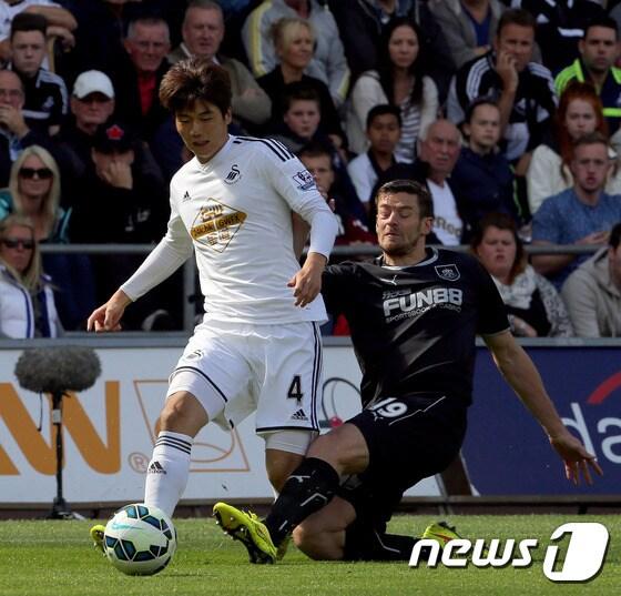 본문 이미지 - 스완지시티 기성용이 23일(한국시간) 영국 스완지 리버티 스타디움에서 열린 2014-2015 EPL 2라운드 번리와의 경기에서 상대 태클을 피해 드리블하고 있다. ⓒ AFP=News1