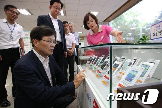 본문 이미지 - 최양희 미래창조과학부 장관이 29일 오전 추석을 맞아 경기도 안양시 동안구 평촌대로 안양우체국을 방문해 우체국 직원으로부터 알뜰폰에 대한 설명을 듣고 있다. (미래창조과학부 제공) 2014.8.29/뉴스1