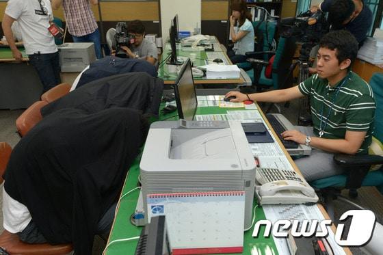 본문 이미지 - 서대문경찰서 수사과 지능범죄팀 경찰이 6일 오전 서울 서대문구 미근동 서대문경찰서에서 보이스피싱-대출사기 혐의로 검거된 중국 콜센터 일당을 조사하고 있다.  2014.8.6/뉴스1 ⓒ News1 민경석 기자