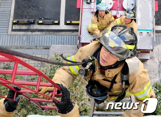 본문 이미지 - 23일 오전 대구시 동구 율하 휴먼시아에서 대구소방본부가 주최한 인명구조 화재진압훈련이 열렸다. 소방관들이 사다리와 특수차를 이용해 인명을 구조하기 위한 훈련을 실시하고 있다. 2014.9.23./뉴스1 2014.09.23/뉴스1 ⓒ News1 정훈진 기자